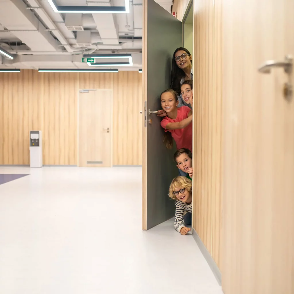 Pädagogische Begleitung in der Phase 0 - Schüler und Lehrerin schauen durch Türspalt